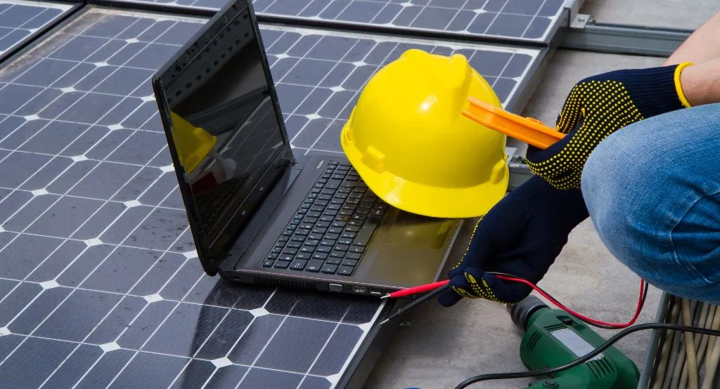 Seorang teknisi tersenyum sambil memegang tablet.