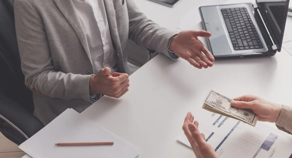 Seseorang melakukan pembayaran menggunakan kartu kredit di laptop.